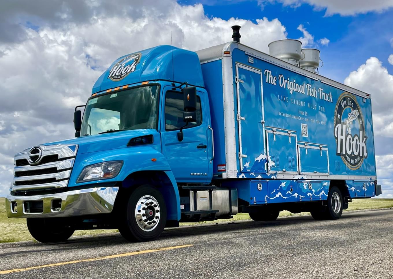 A truck with a hook logo on it on the highway